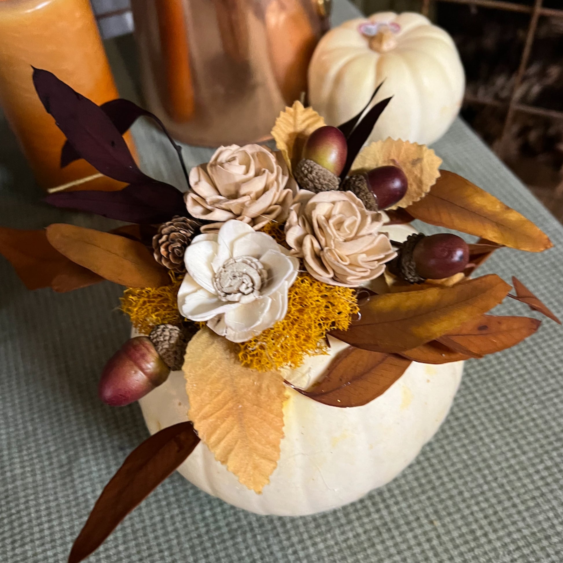 Decorative pumpkin with flowers and leaves on a checkered tablecloth