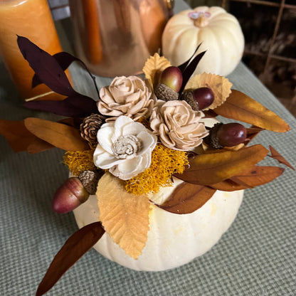 Decorative pumpkin with flowers and leaves on a checkered tablecloth