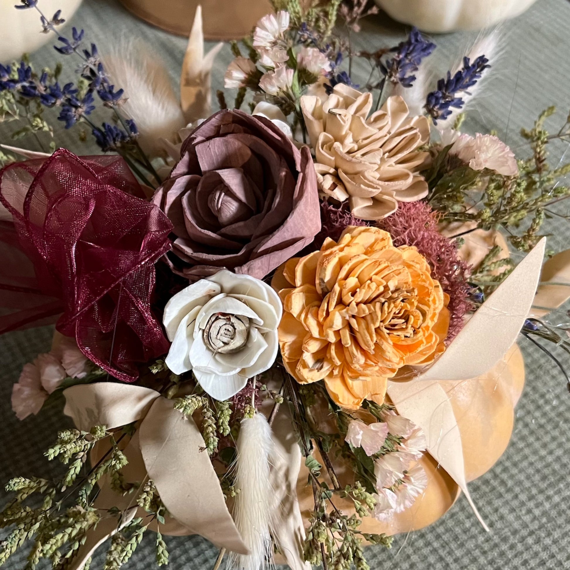Bouquet of artificial flowers with various colors on a textured surface