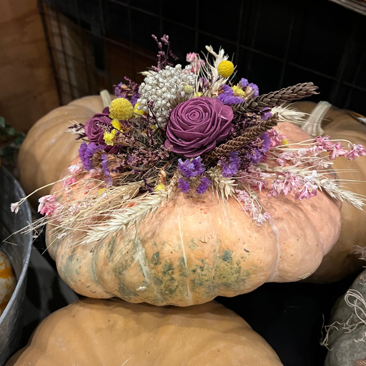 Decorative pumpkin with flowers and herbs on a dark background